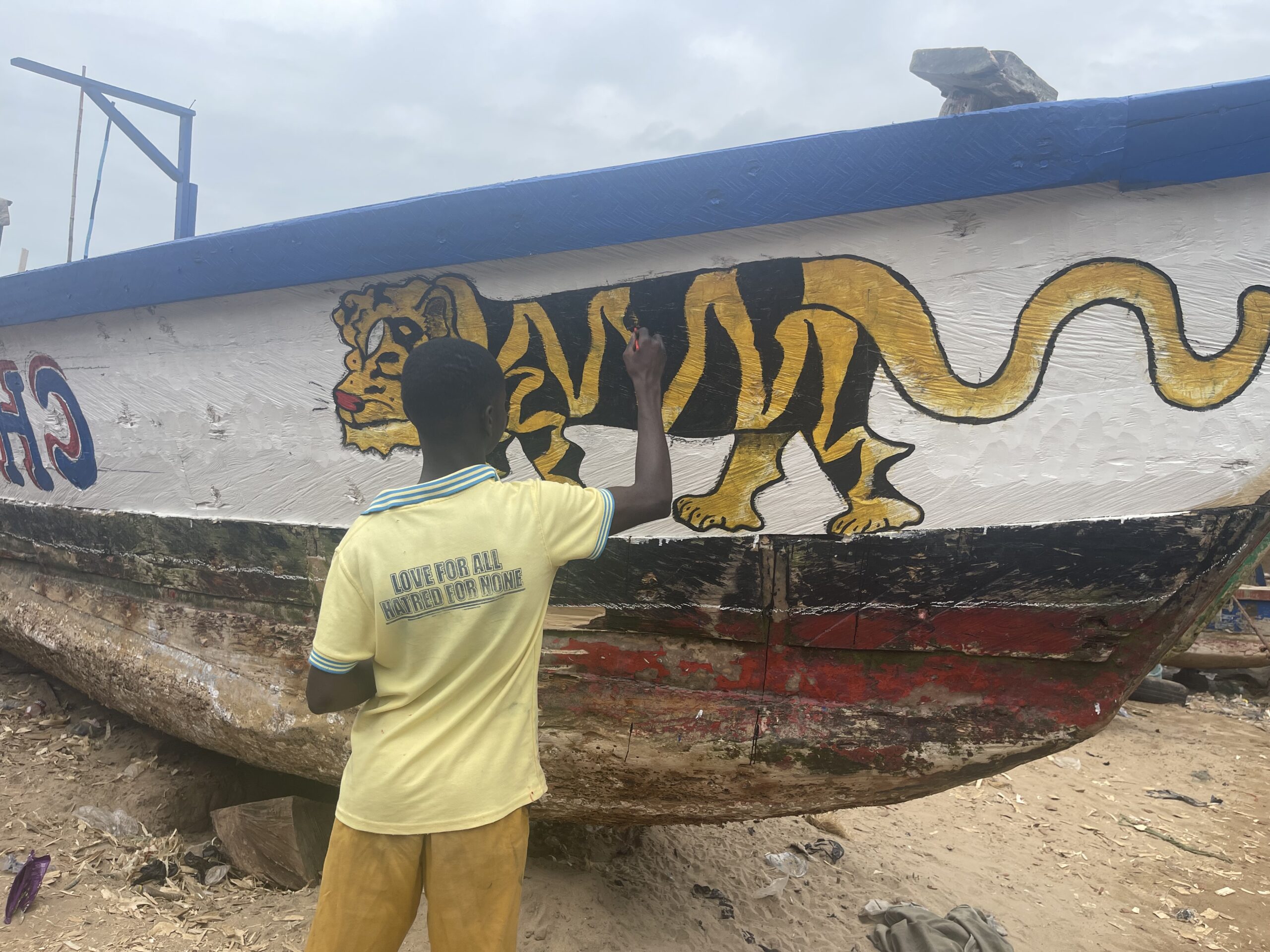 A canoe in Abuesi being painted in preparation for the resumption of the fishing season